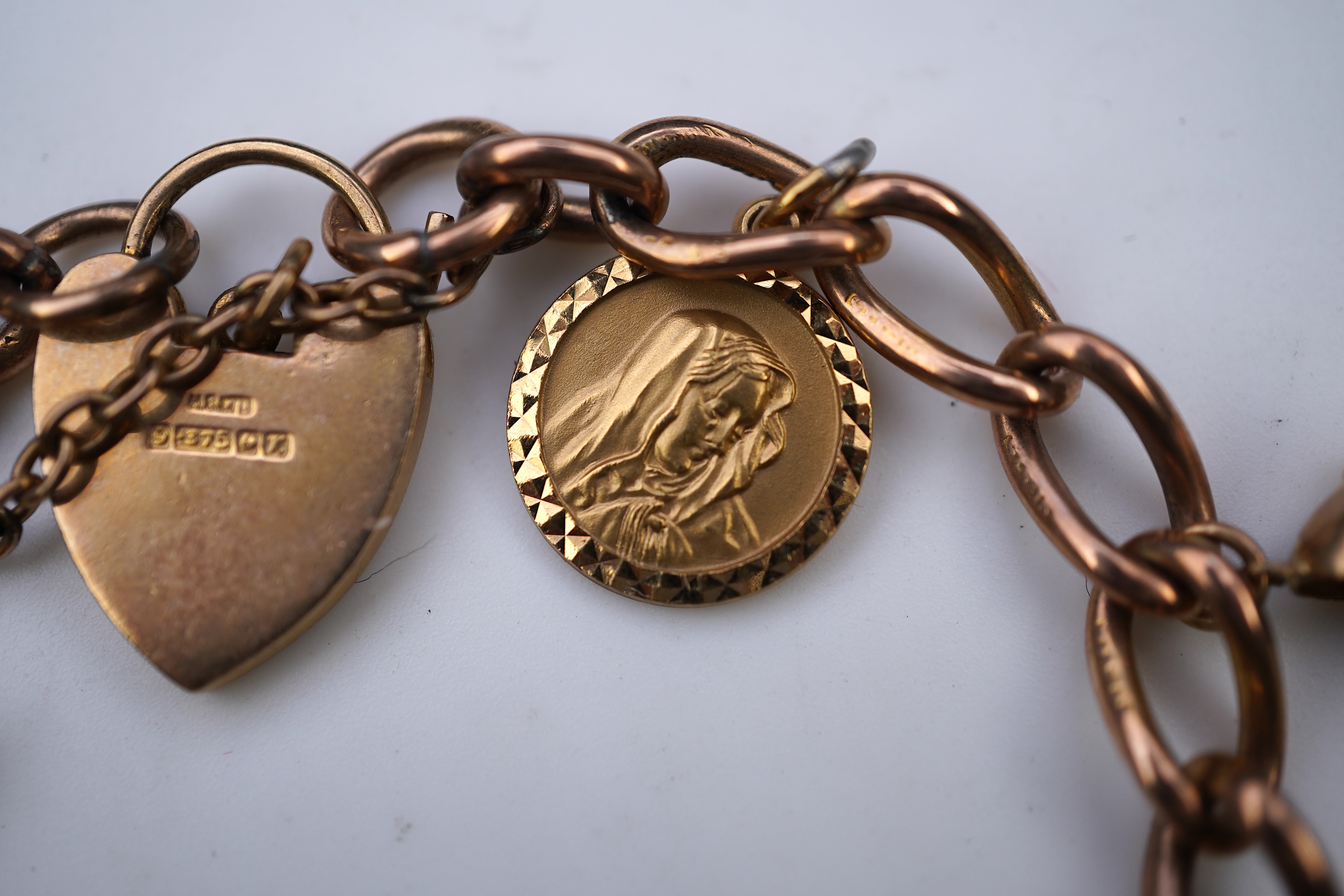 A gold charm bracelet, mid 20th century